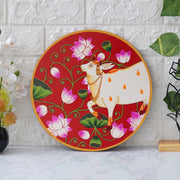 This beautiful pichwai painting features a serene white cow adorned with a vibrant floral headdress.
